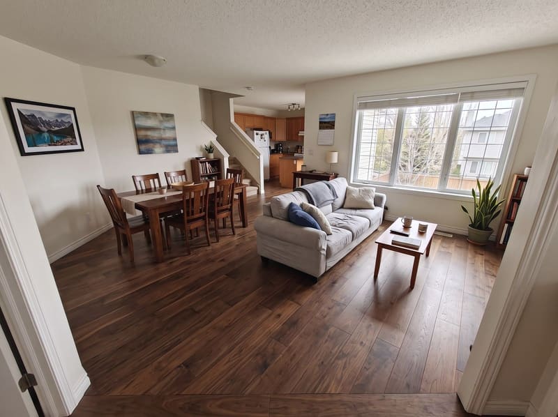 After: the same open living and dining room with Walnut hardwood, rendered by the Flooring Local visualizer