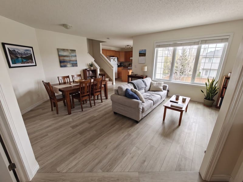 After: the same open living and dining room with Greige Oak vinyl plank, rendered by the Flooring Local visualizer