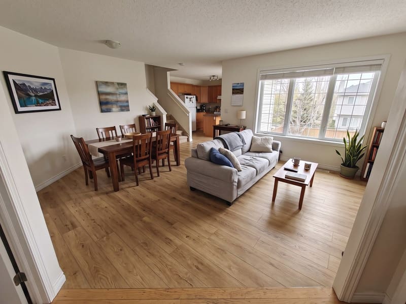 After: the same open living and dining room with Honey Oak vinyl plank, rendered by the Flooring Local visualizer