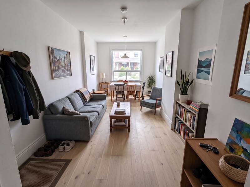 Across the room floor: the same long, narrow living and dining room with White Oak, natural hardwood, rendered by the Flooring Local visualizer