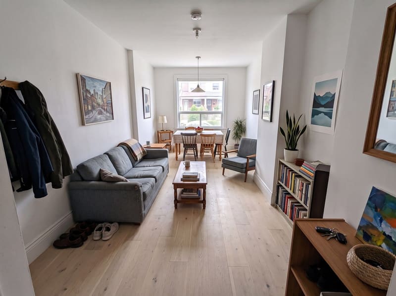 Along the room floor: the same long, narrow living and dining room with White Oak, natural hardwood, rendered by the Flooring Local visualizer