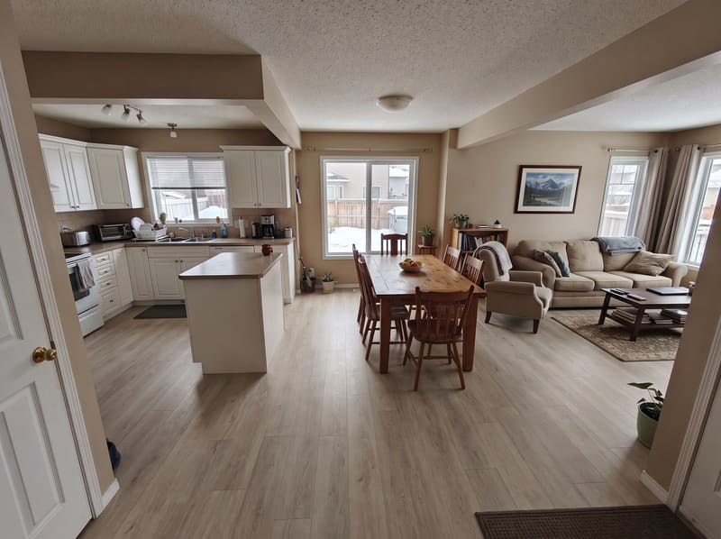 After: the same open-plan main floor with Greige Oak vinyl plank, rendered by the Flooring Local visualizer